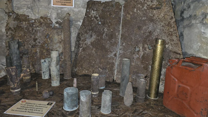 Wyświetlona na zdjęciu wystawa historyczna z eksponatami wojskowymi i elementami architektury obronnej, prawdopodobnie związana z Basztą Kowalską w Nowym Sączu.
